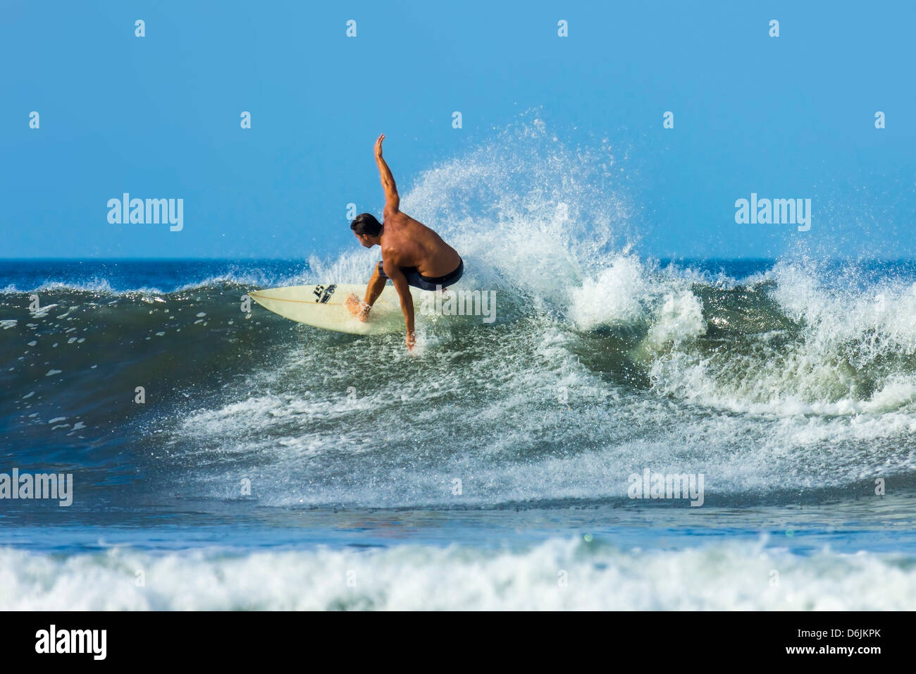 Surfer on shortboard riding wave at popular Playa Guiones surf beach, Nosara, Nicoya Peninsula, Guanacaste Province, Costa Rica Stock Photo