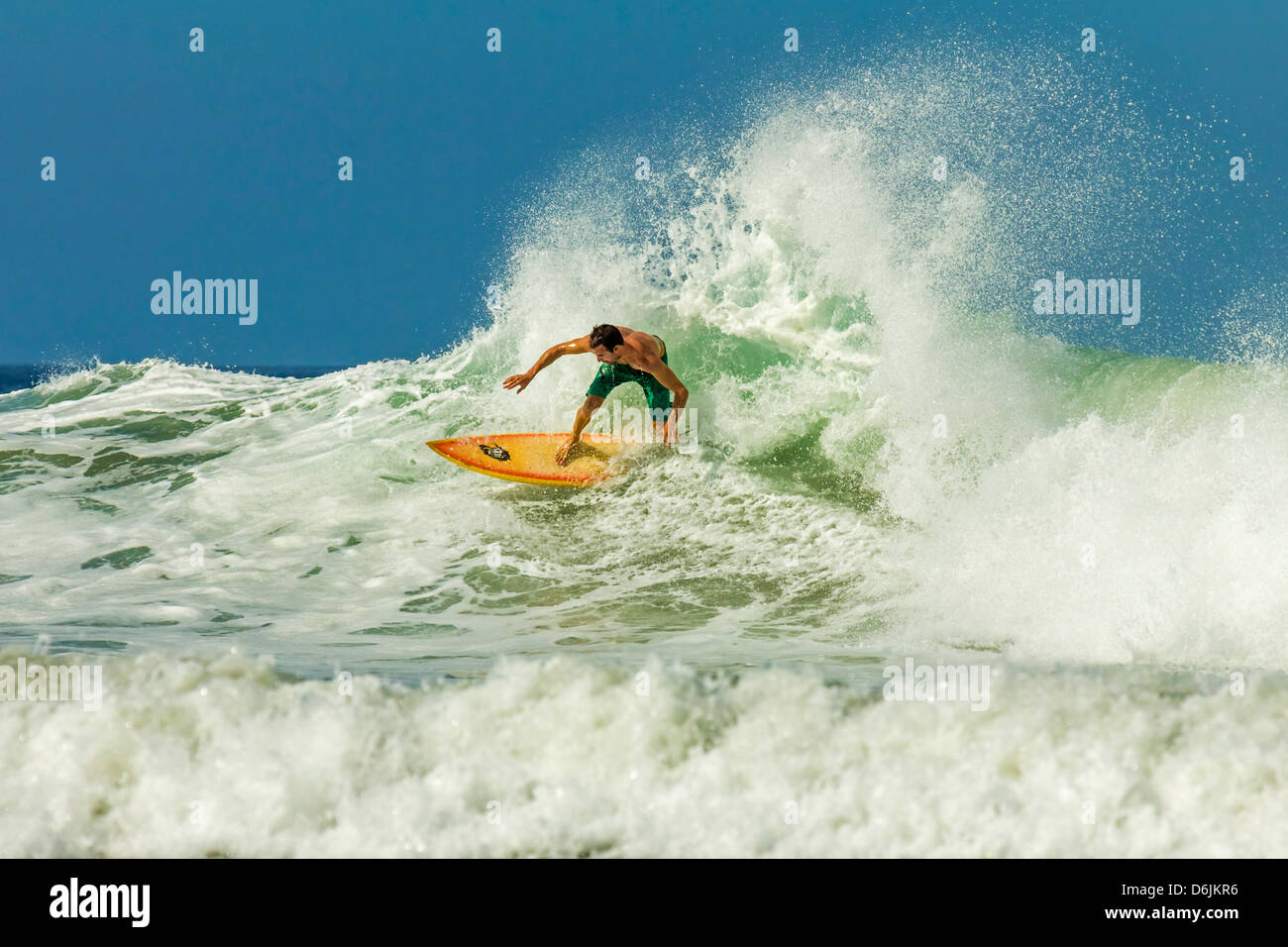 Surfer on shortboard riding wave at popular Playa Guiones surf beach, Nosara, Nicoya Peninsula, Guanacaste Province, Costa Rica Stock Photo