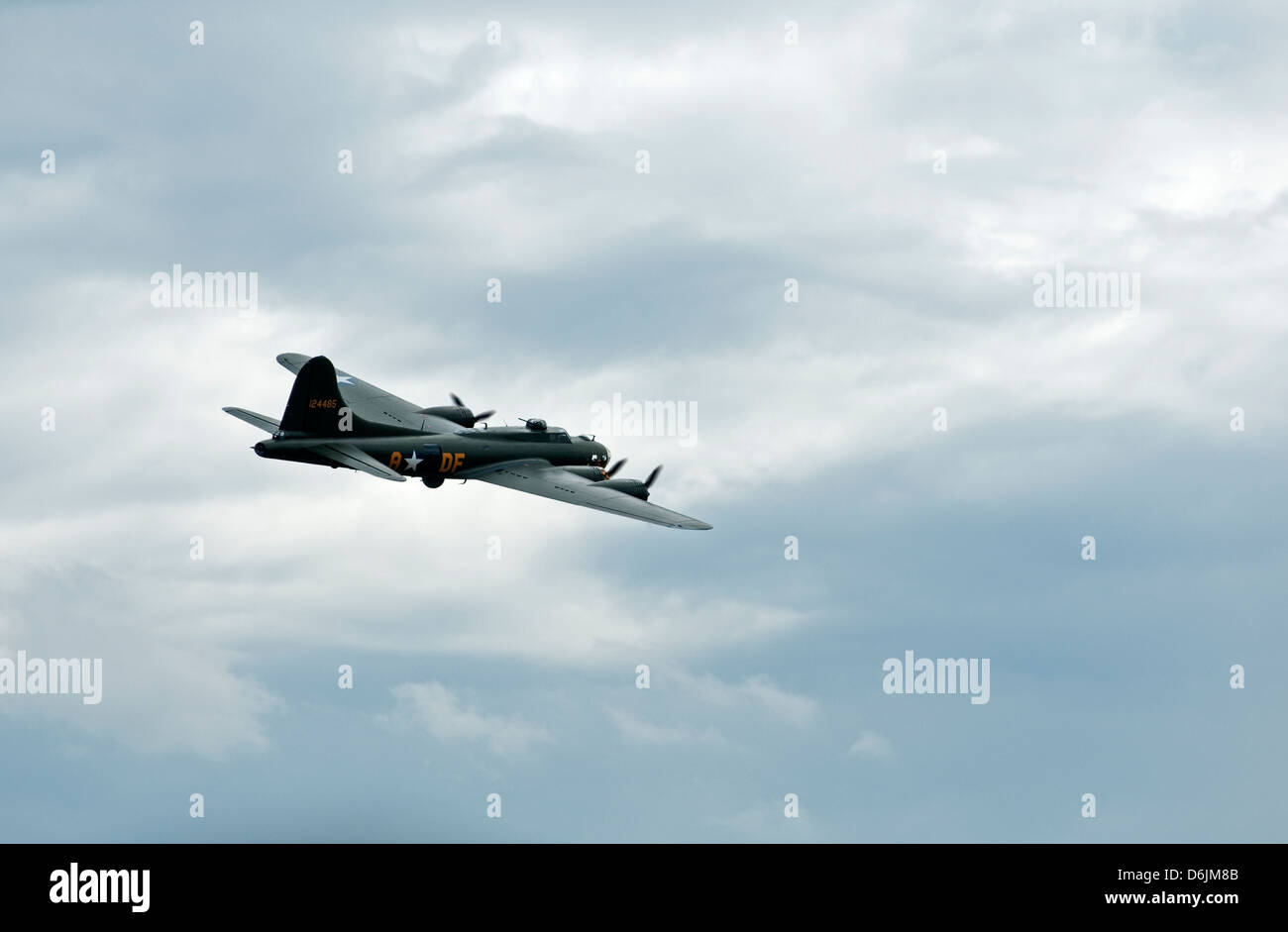 A World war two USAF B17 aircraft performs a fly past, isolated against a grey cloudy sky. Stock Photo