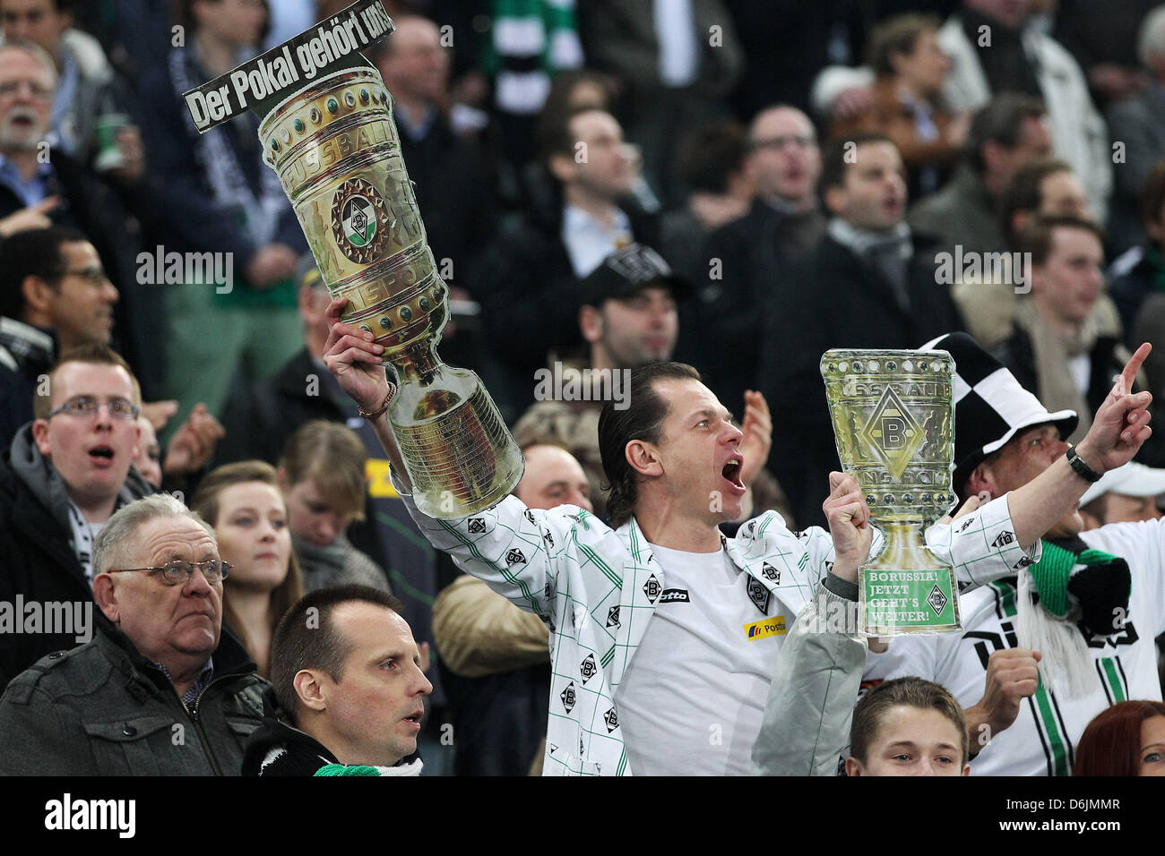 A fan of Moenchengladbach holds up a paper model of the Cup trophy during the DFB Cup semifinal soccer match between Borussia Moenchengladbacj and Bayern Munich at the Borussia Park in Moenchengladbach, Germany, 21 March 2012. Photo: Revierfoto Stock Photo
