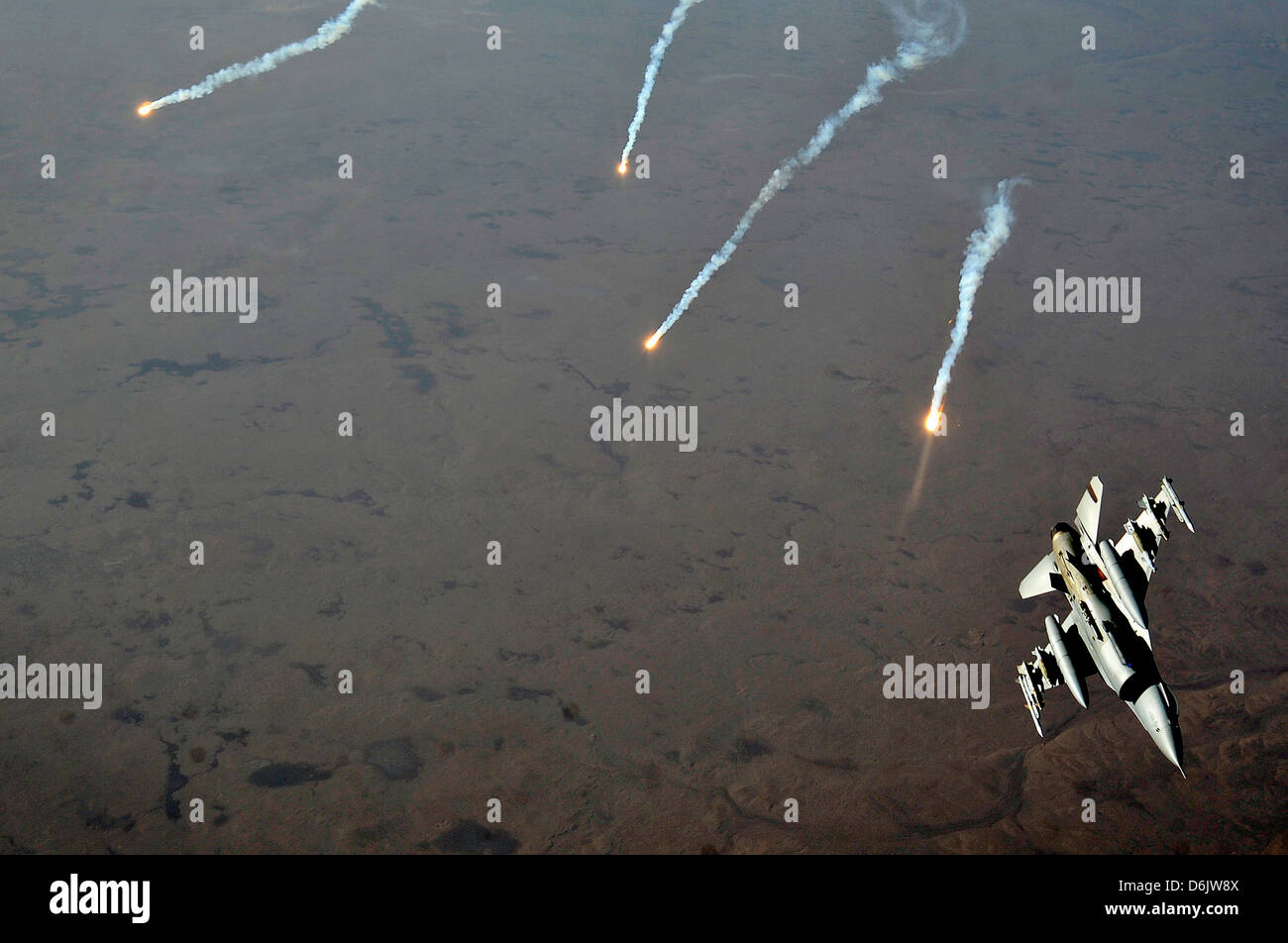 A US Air Force F-16 Fighting Falcon aircraft releases flare decoys November 9, 2011 over Iraq. Stock Photo