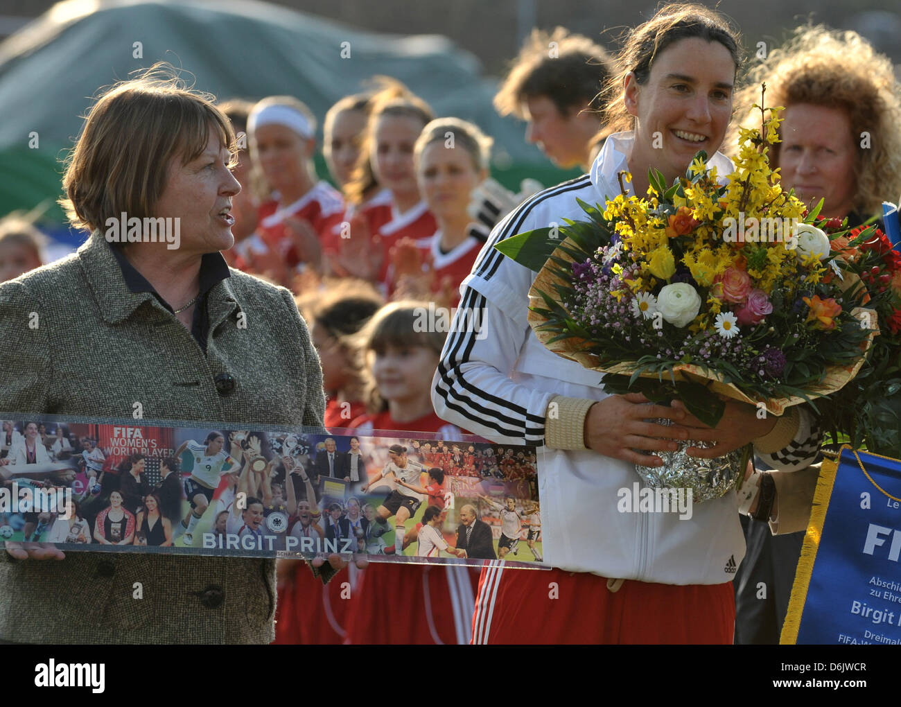 DFB record national soccer team player Birgit Prinz holds flowers next to Hannelore Ratzburg (2-R), Vice President for women's and girls' soccer stands in the DFB, on the pitch before her farewell match between FFC Frankfurt and Germany at Volksbank Stadium in Frankfurt Main, Germany, 27 March 2012. 34 year old Prinz played a half match for both her home club FFC Frankfurt and the  Stock Photo