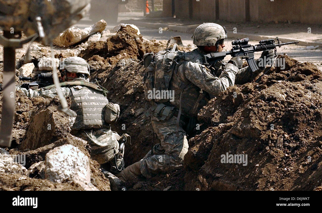 US soldiers take cover during a firefight with insurgent forces in the Al Doura section of Baghdad March 7, 2007 in Baghdad, Iraq. Stock Photo