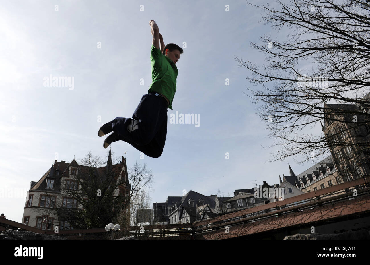 Marko jumps over the fountain on Rudolphsplatz in Marburg, Germany, 27 March 2012. Parkour is a sport which emphasizes efficient movement around obstacles. Photo: Uwe Zucchi Stock Photo