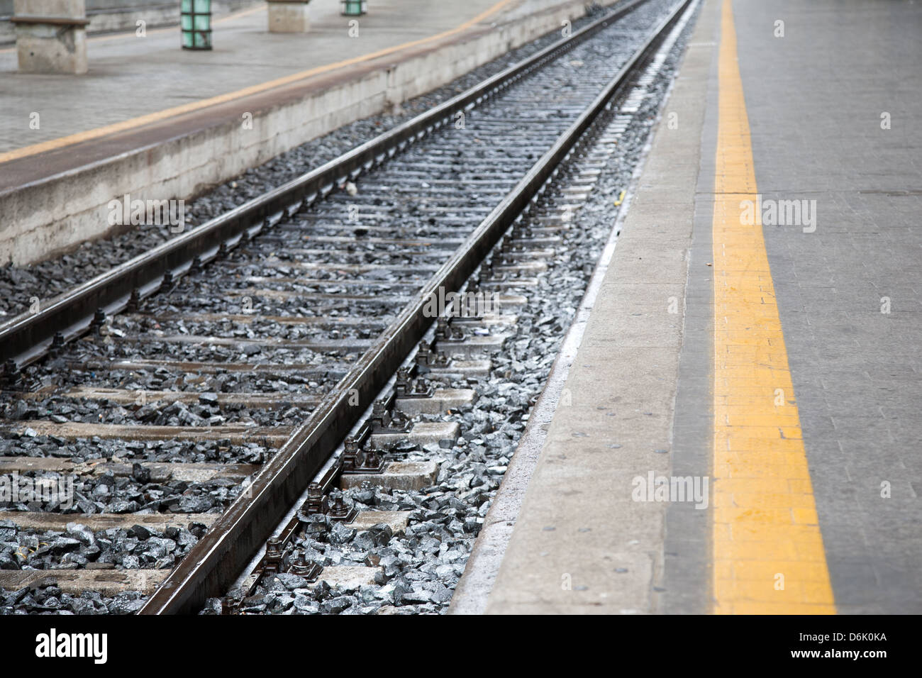 Wet Railway Tracks and Platform with Yellow Line Stock Photo