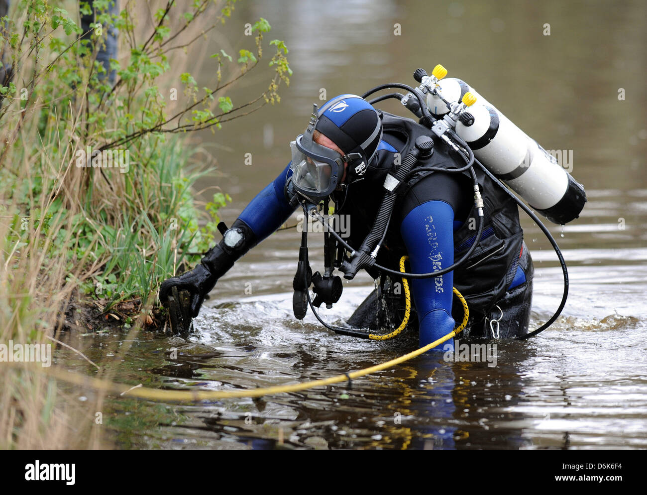 A police divers climbs into a moat to look for the murder weapon in the murder case Lena in Emden, Germany, 04 April 2012. The 18 year old alleged perpetrator in the murder case of an eleven year old girl was arrested on 31 March 2012. Photo: INGO WAGNER Stock Photo