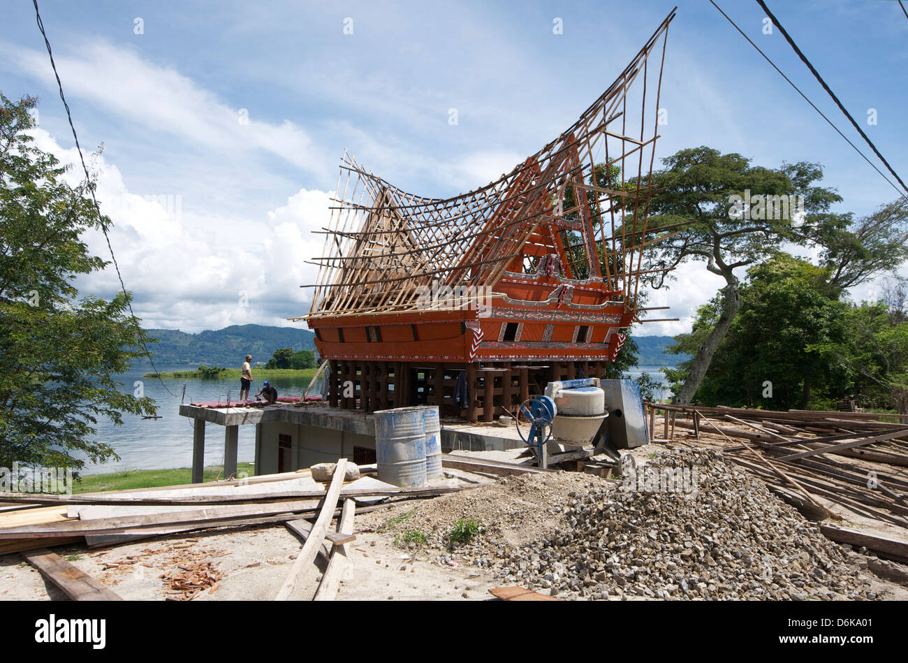 Construction of a Batak house with bamboo scaffolding, beside the volcanic Lake Toba, Samosir Island, Sumatra, Indonesia Stock Photo