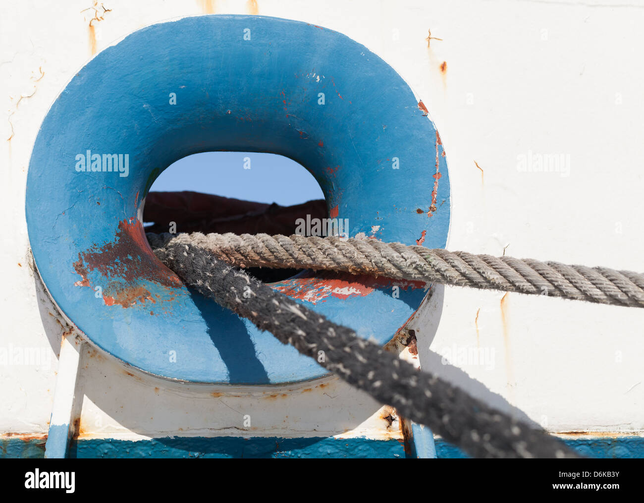 Blue ship hawse on white hull with mooring ropes Stock Photo