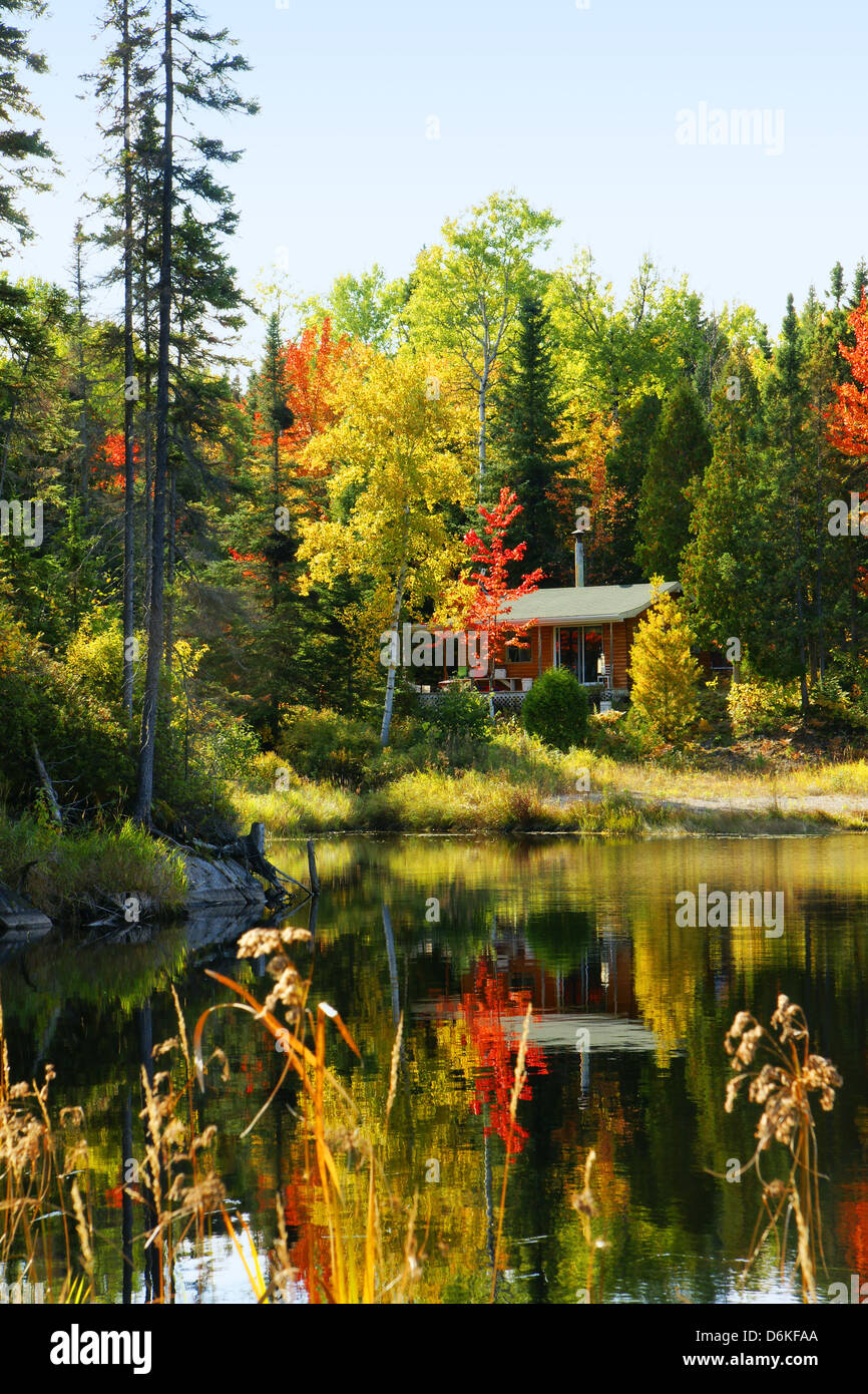 Wood Cabin By A Lake In Beautiful Fall Forest Stock Photo