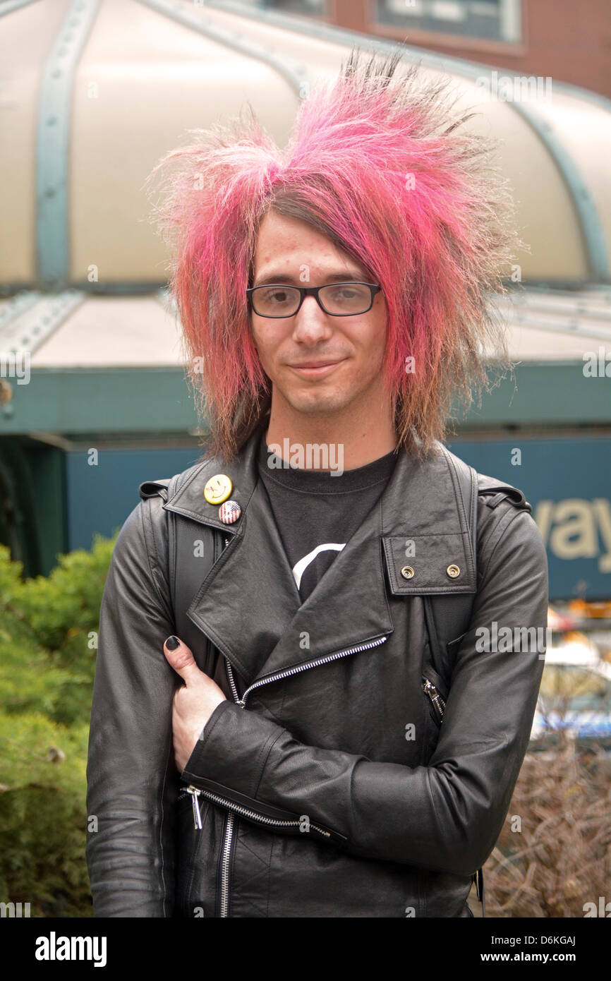 Portrait of a young man in Union Square Park in New York City with long wild pink hair Stock Photo