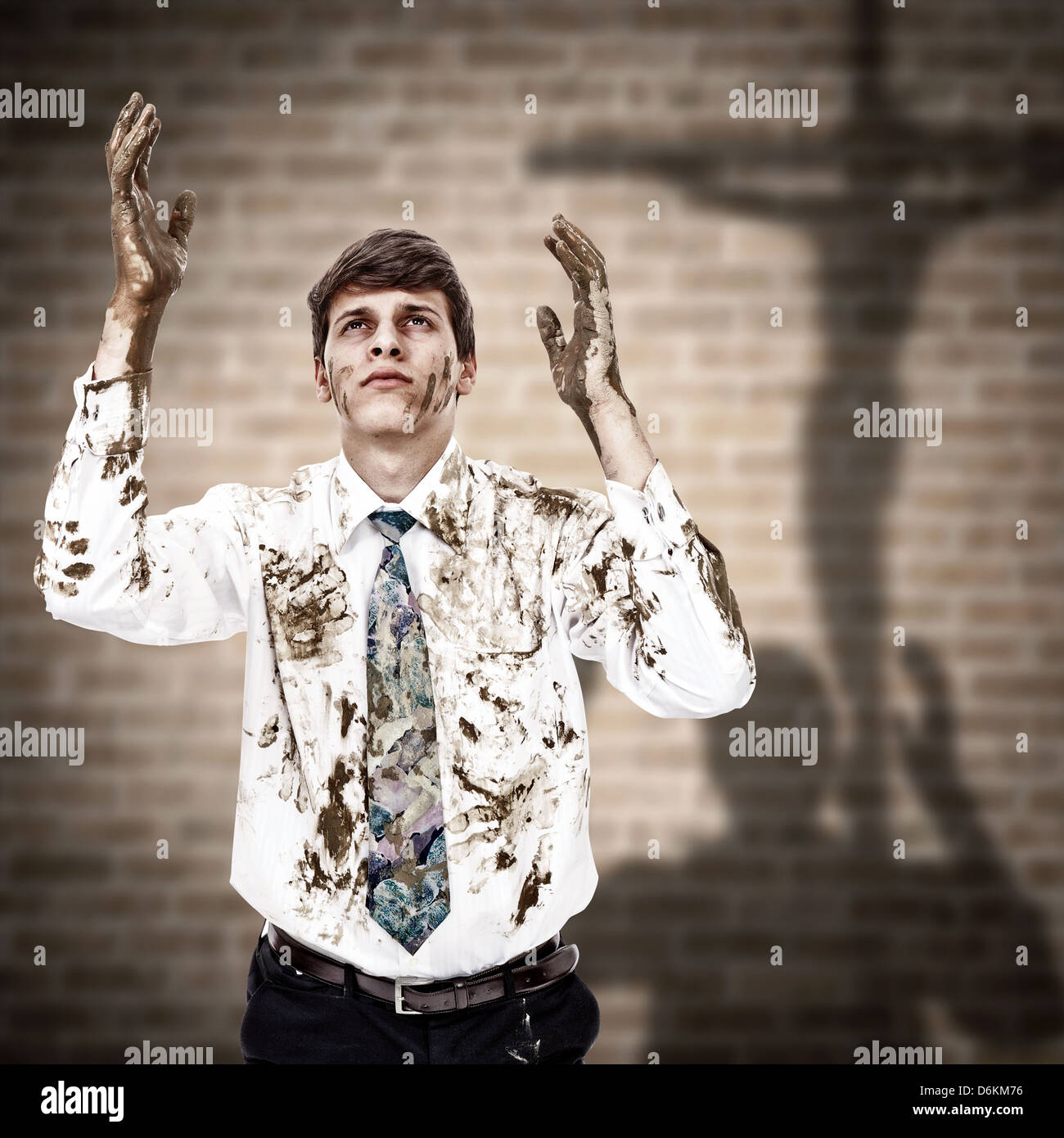 Young man coming to the Jesus cross with his dirty hands and clothes Stock Photo