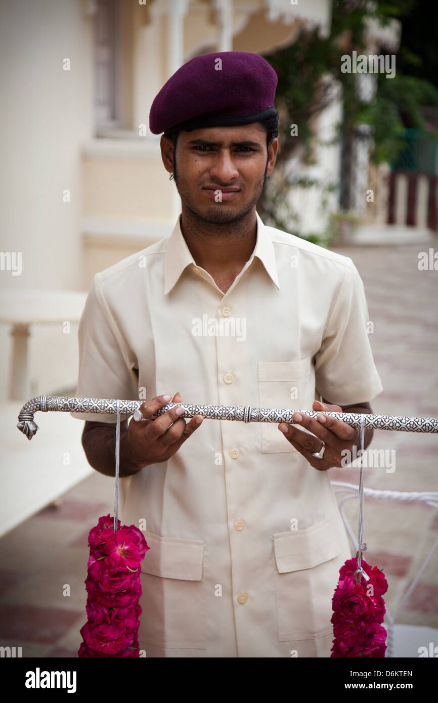A servant holds a traditional Indian garland at a ceremony in