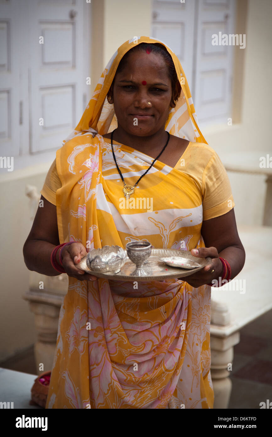 A woman holds a traditional India tea set at a ceremony in