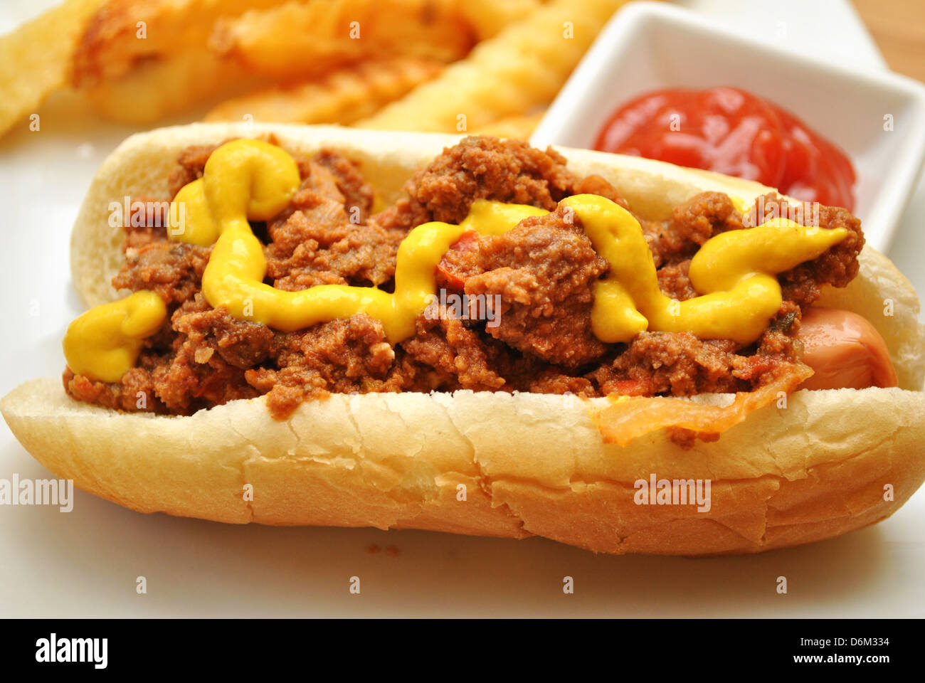 Chili Dog and Mustard with Catsup and French Fries in the Background Stock Photo Alamy