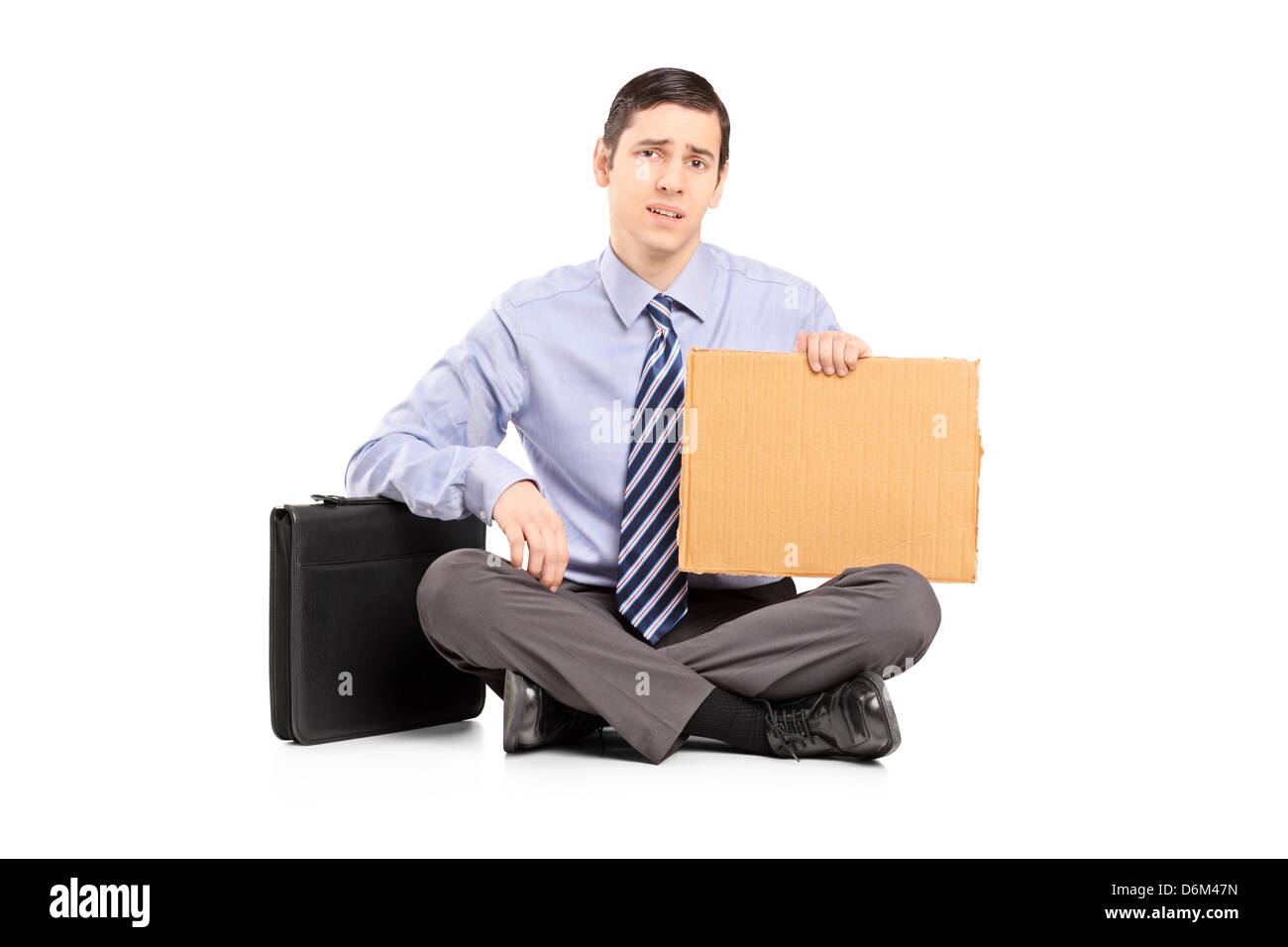 Broke businessman begging with a piece of cardboard, isolated on white background Stock Photo