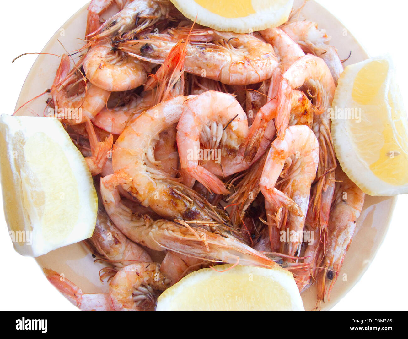 Plate of freshly grilled shrimp in the shell, with lemon wedges Stock Photo