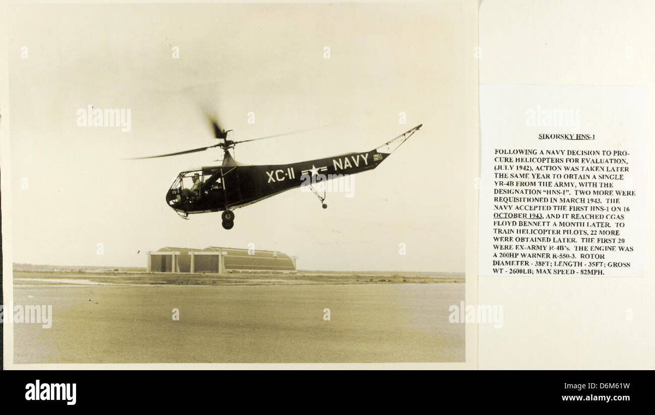 Sikorsky HNS-1 (#XC-11) BuNo 39037 of VX-3 inflight over water with 2 large hangers in the background NHHS Photo Stock Photo