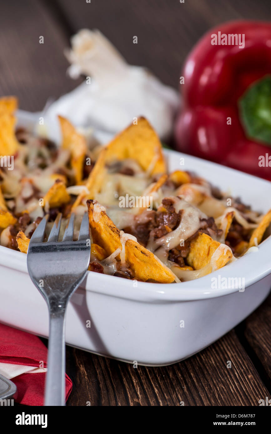 Nachos with Chili con Carne gratinated with cheese Stock Photo - Alamy