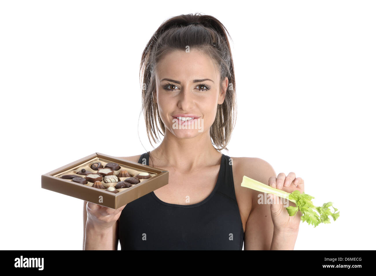 Model Released. Woman Holding Celery and Chocolates Stock Photo
