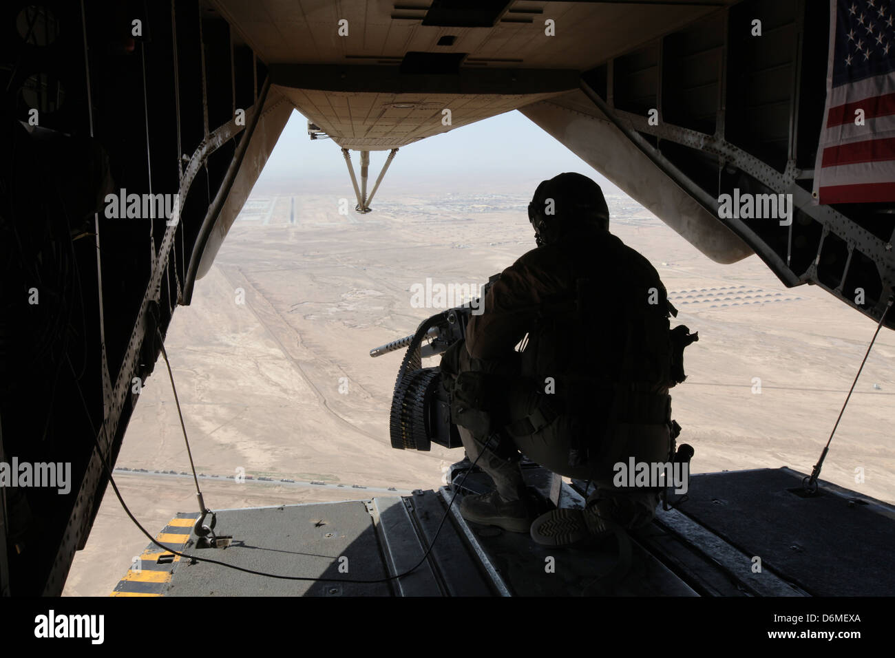 A US Marine door gunner provides security from a CH-53E Super Stallion helicopter during operations April 10, 2013 in Helmand province, Afghanistan. Stock Photo