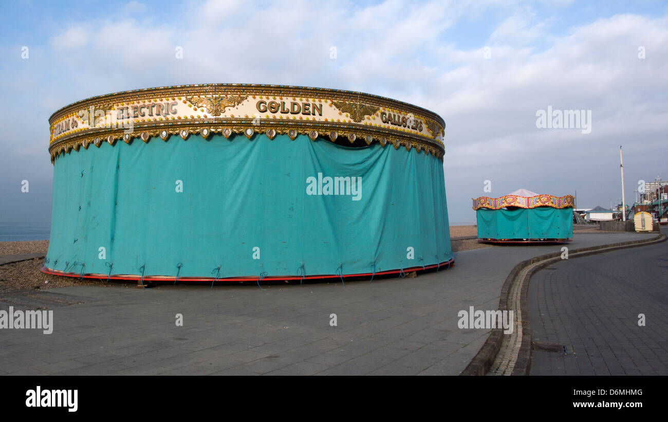 Fairground carousels under cover, green tarpaulins, Brighton seafront Stock Photo