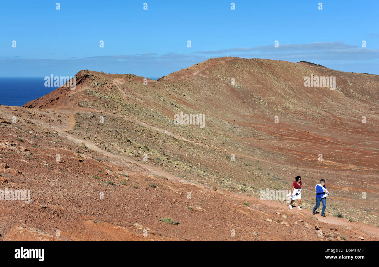 Two ladies walking on volcano, Montana Roja, a popular destination for  holidaymakers in Playa Blanca, Lanzarote Stock Photo - Alamy