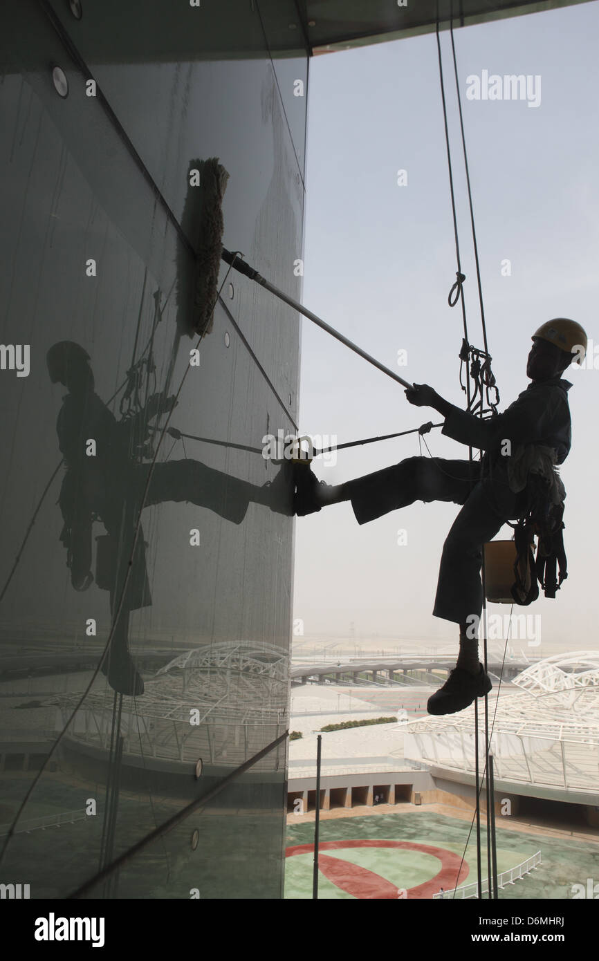 Dubai, United Arab Emirates, silhouette, window cleaners at work on a glass facade Stock Photo
