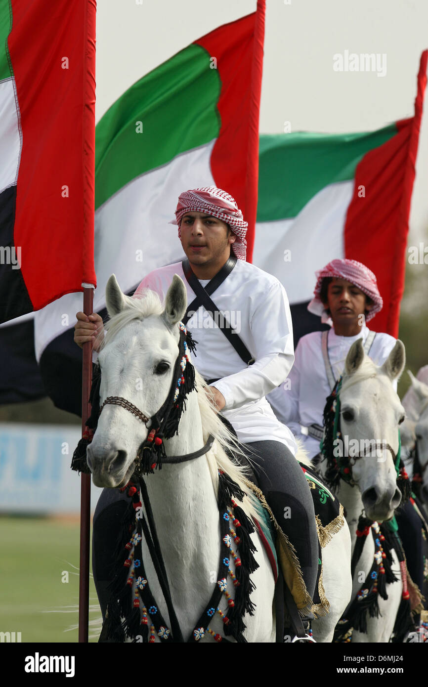 Dubai, riders with national flag on Arab thoroughbreds Stock Photo