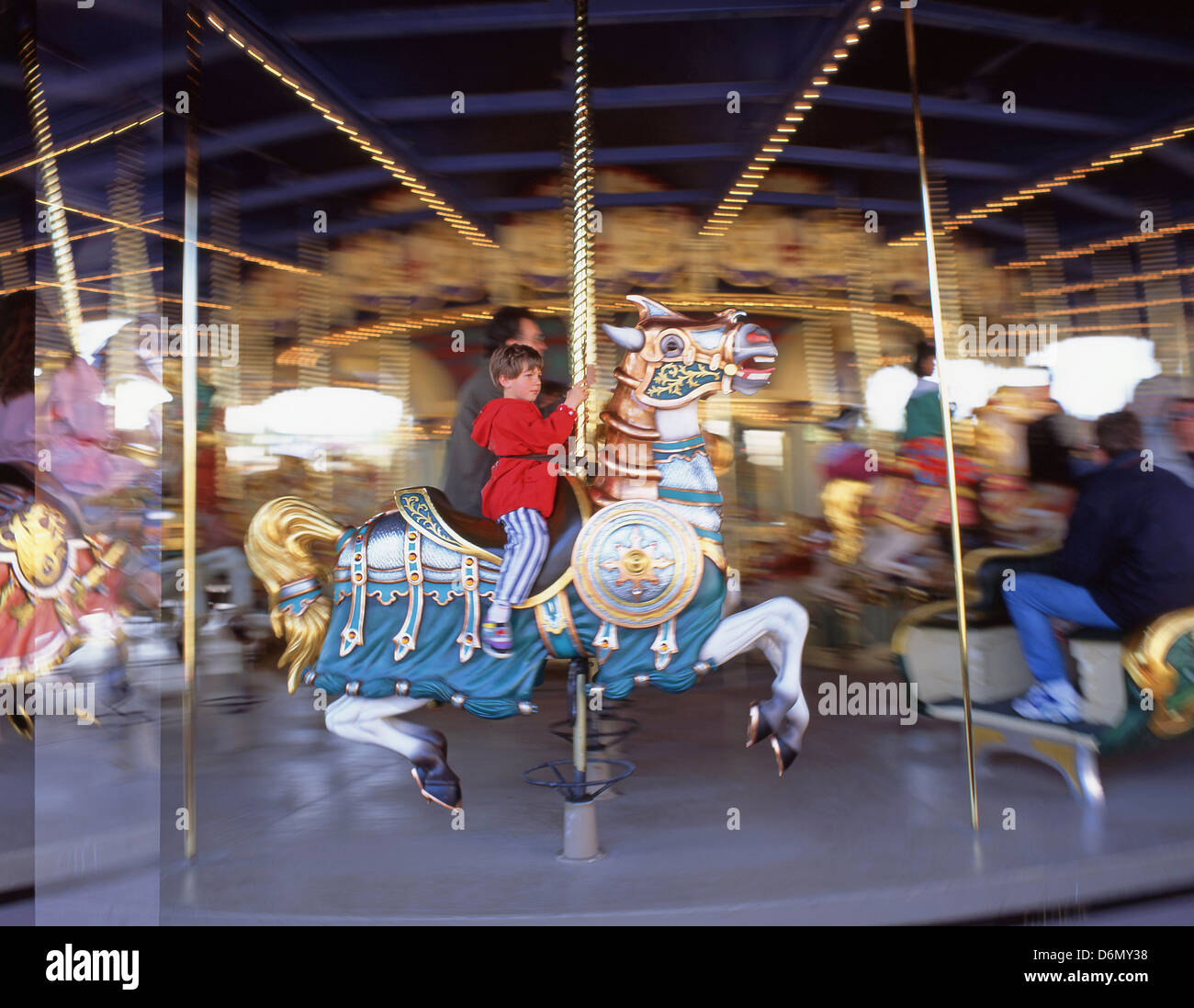 Young boy on carousel, Fantasyland, Disneyland Paris theme park, Marne-la-Vallée, Île-de-France, France Stock Photo