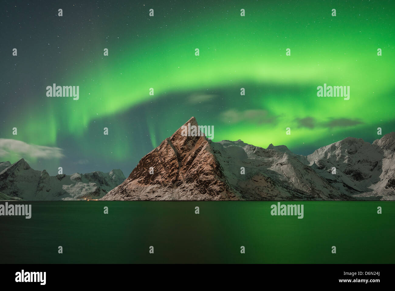 Aurora Borealis - Northern Lights fill sky over Olstind mountain peak and reflect in fjord, Toppøya, Lofoten Islands, Norway Stock Photo