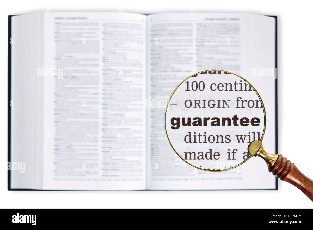 A magnifying glass held over a dictionary looking at the word Guarantee enlarged Stock Photo