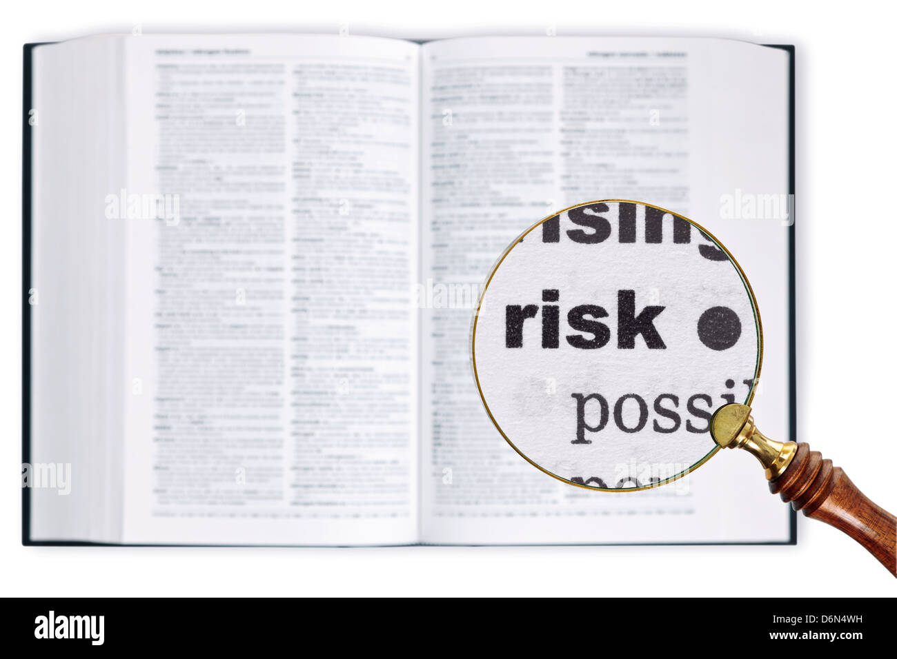 A magnifying glass held over a dictionary looking at the word Risk enlarged Stock Photo