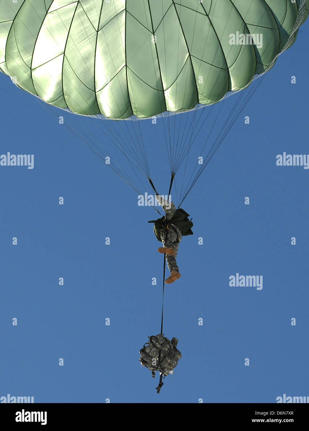 US Army paratrooper soldiers parachute during an airdrop exercise April 17, 2013 at the Malemute Drop Zone, Alaska. Stock Photo