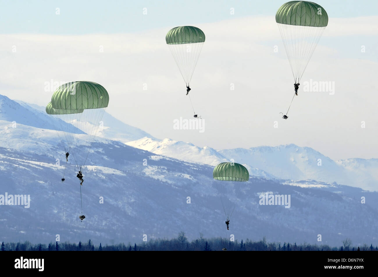 US Army paratrooper soldiers parachute during an airdrop exercise April 17, 2013 at the Malemute Drop Zone, Alaska. Stock Photo