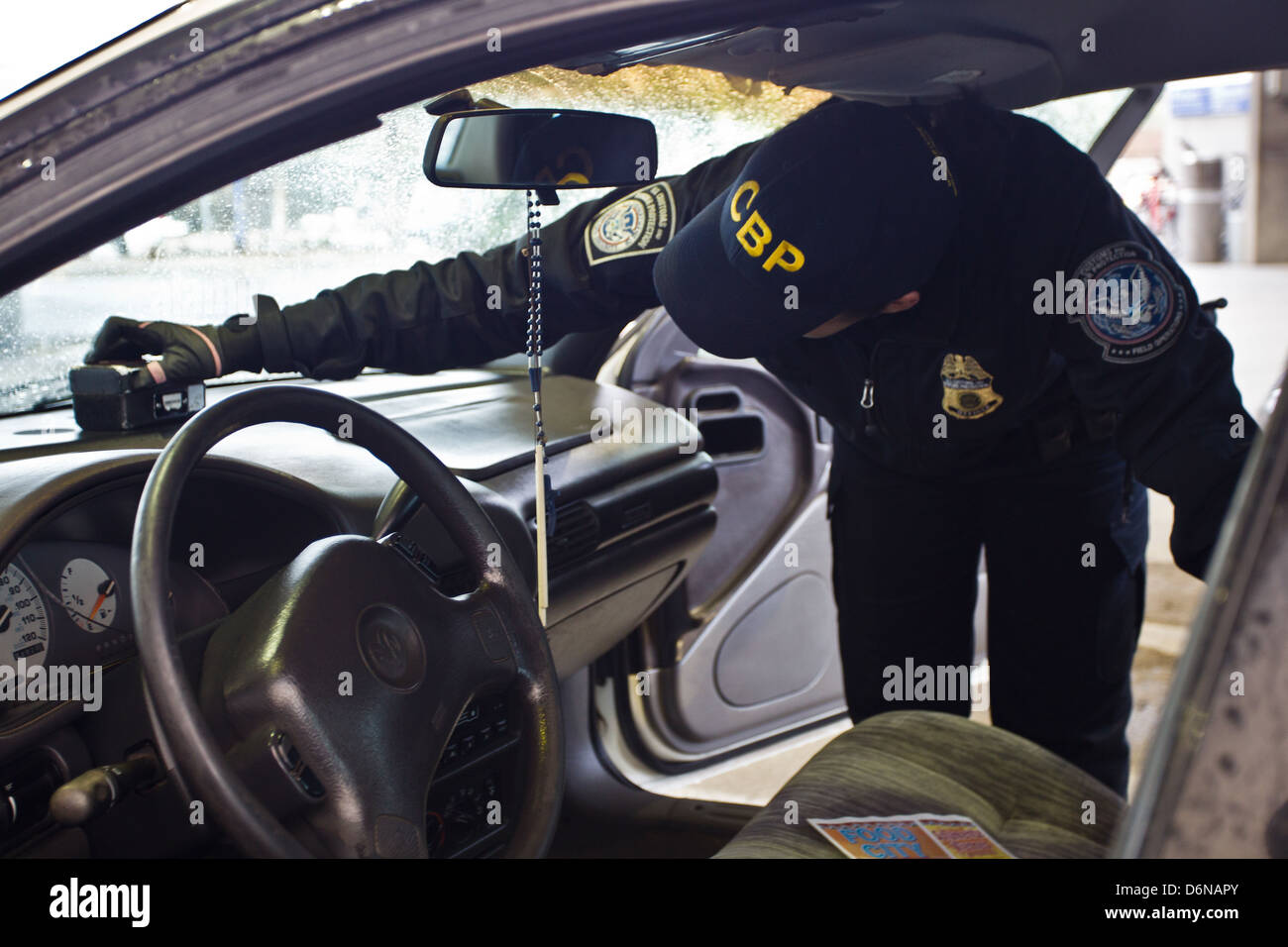 A US Customs and Border Protection officer uses a contraband detection device known as a buster to inspect a vehicle at the San Luis border crossing February 16, 2012 in San Luis, AZ. Stock Photo