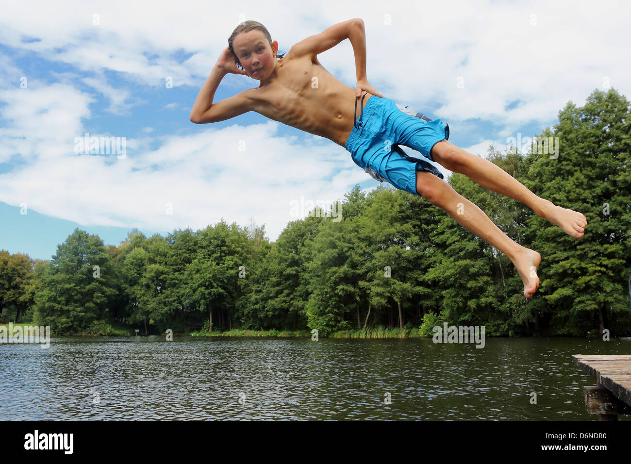 Emstal, Germany, boy jumping in a cool pose in the pool into the Stock