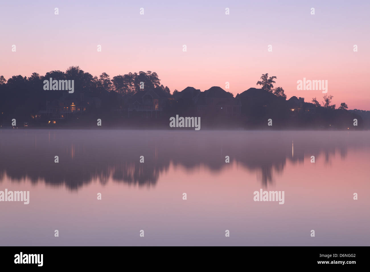 Misty morning at the lake with houses Stock Photo - Alamy
