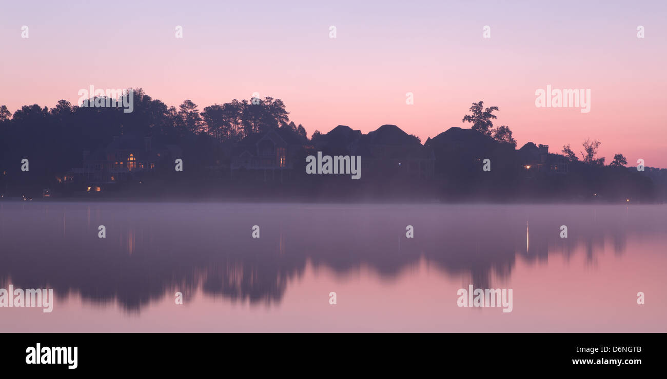 Misty morning at the lake with houses Stock Photo - Alamy