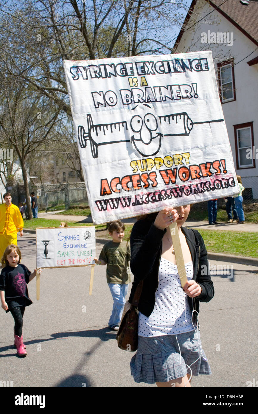 Woman and children carrying banners for syringe exchange to save lives. MayDay Parade and Festival Minneapolis Minnesota MN USA Stock Photo
