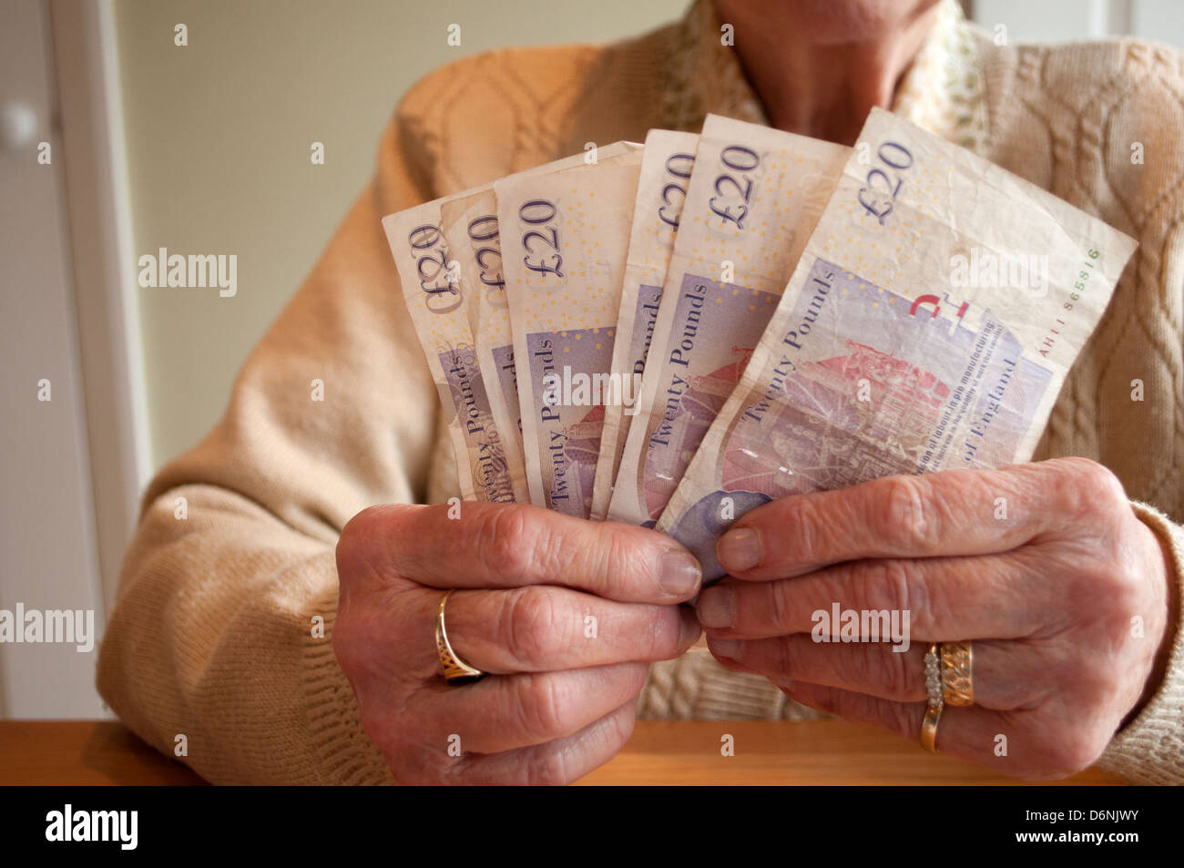 Elderly woman fanning twenty pound notes Stock Photo