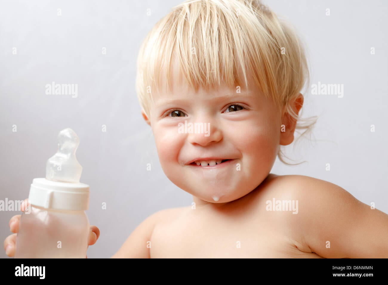 girl drinking bottle of milk laying on bed blond toddler Stock Photo - Alamy