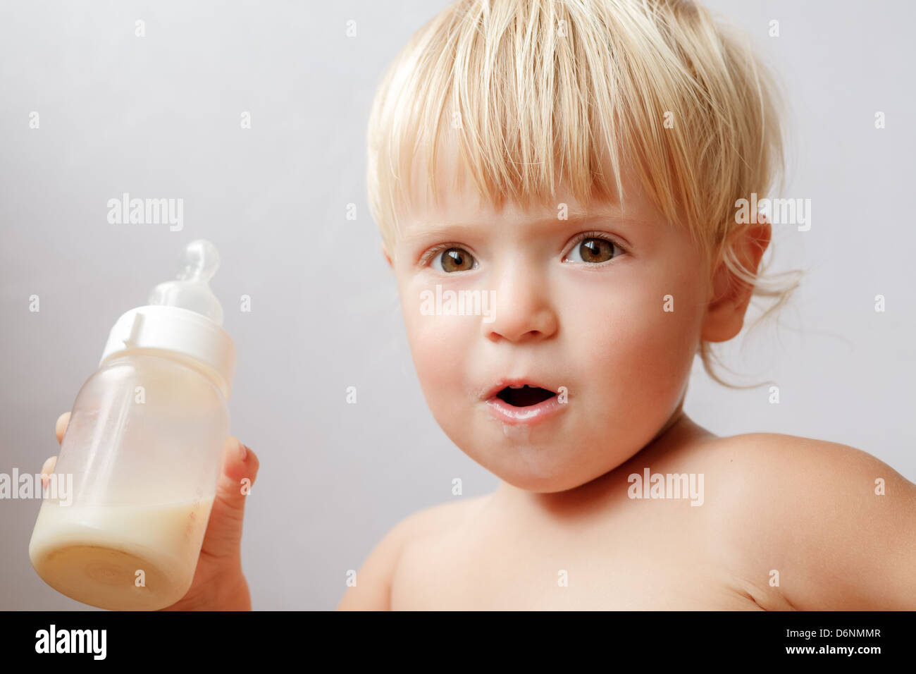 girl drinking bottle of milk laying on bed blond toddler Stock Photo - Alamy