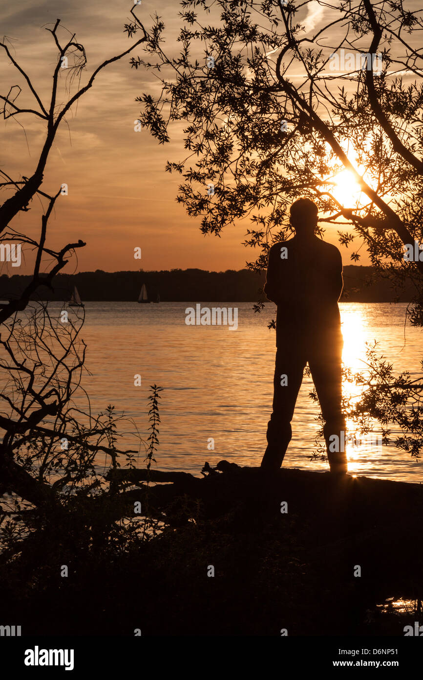 Berlin, Germany, a man stands on the banks of the Havel river at sunset Stock Photo