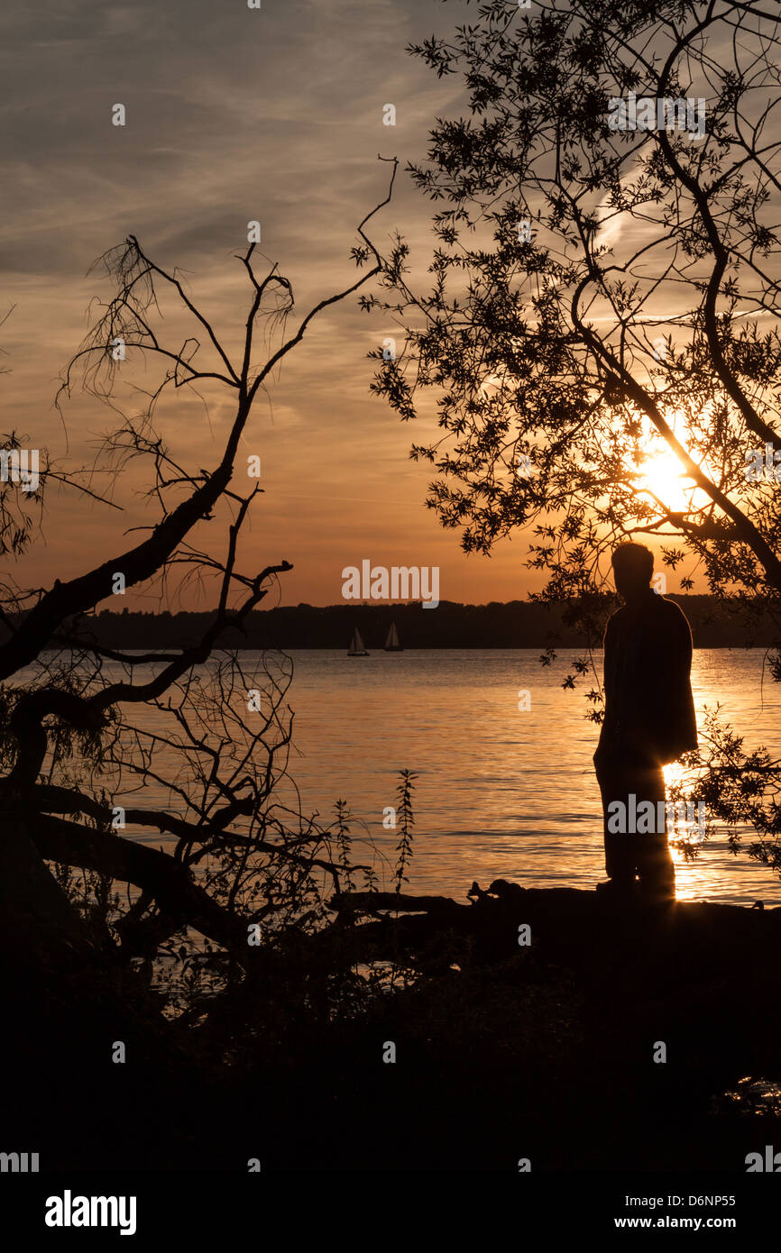 Berlin, Germany, a man stands on the banks of the Havel river at sunset Stock Photo