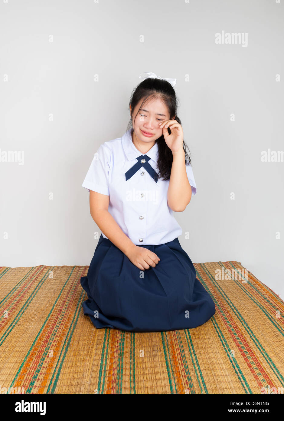 Crying Asian Thai Student in Sitting with Legs Folded Back to One Side Stock Photo