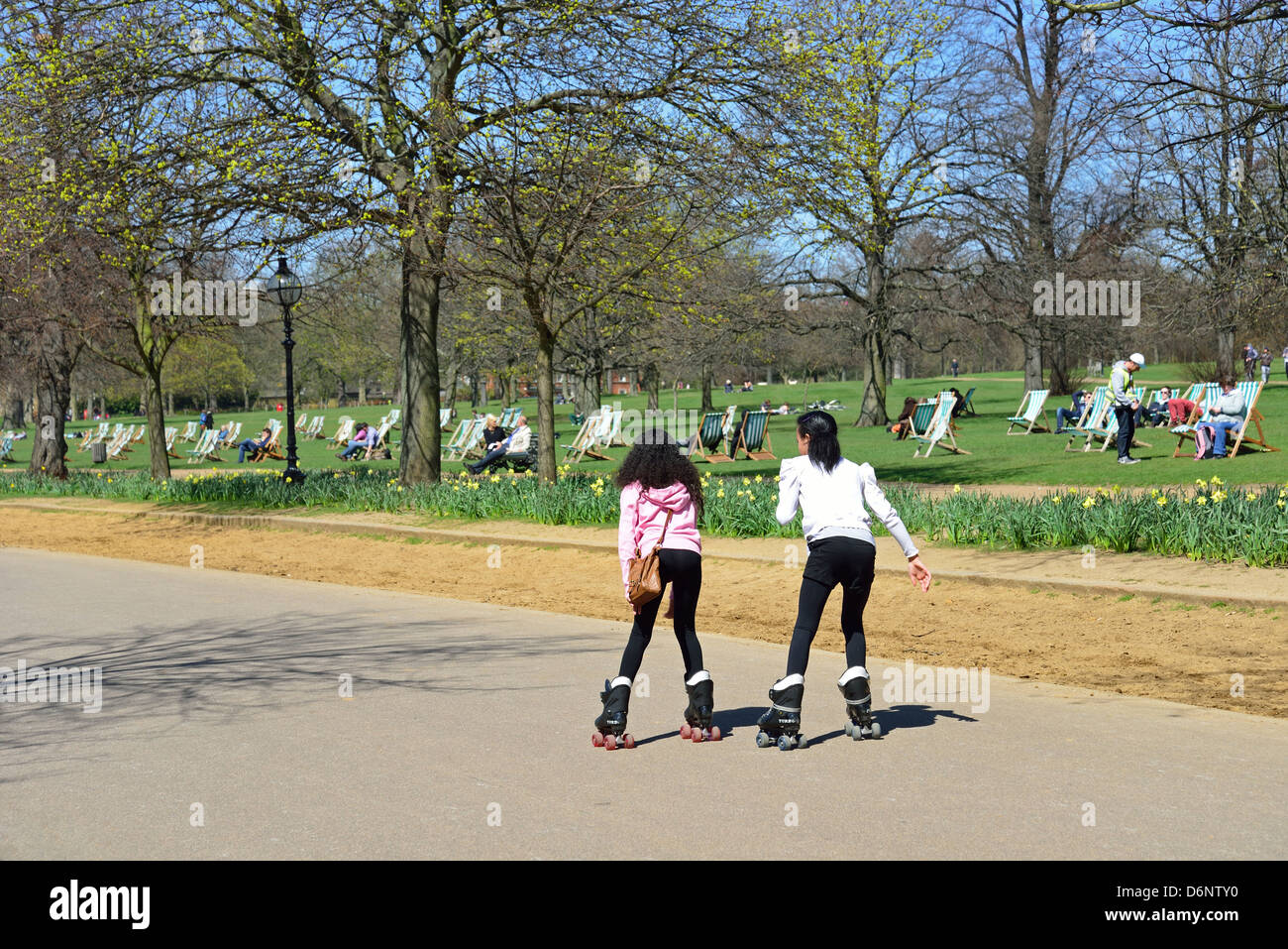 Girls rollerblading on path by The Serpentine, Hyde Park, City of Westminster, London, England, United Kingdom Stock Photo