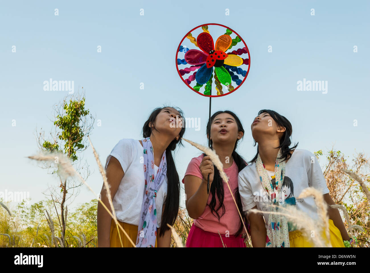 Asian Thai girls are blowing the pin wheel. Stock Photo