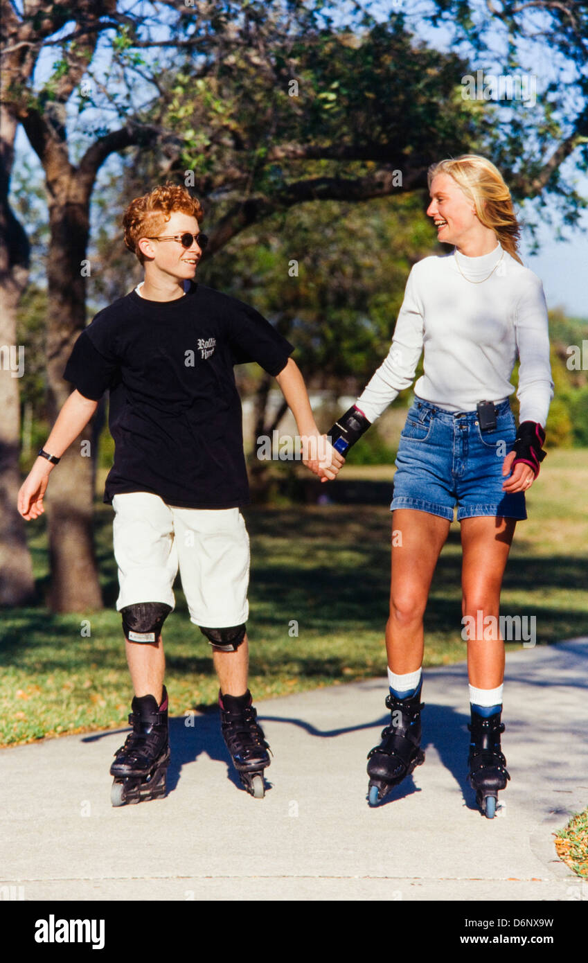 Teenagers rollerblading together, goofing off, teasing, playing Stock Photo