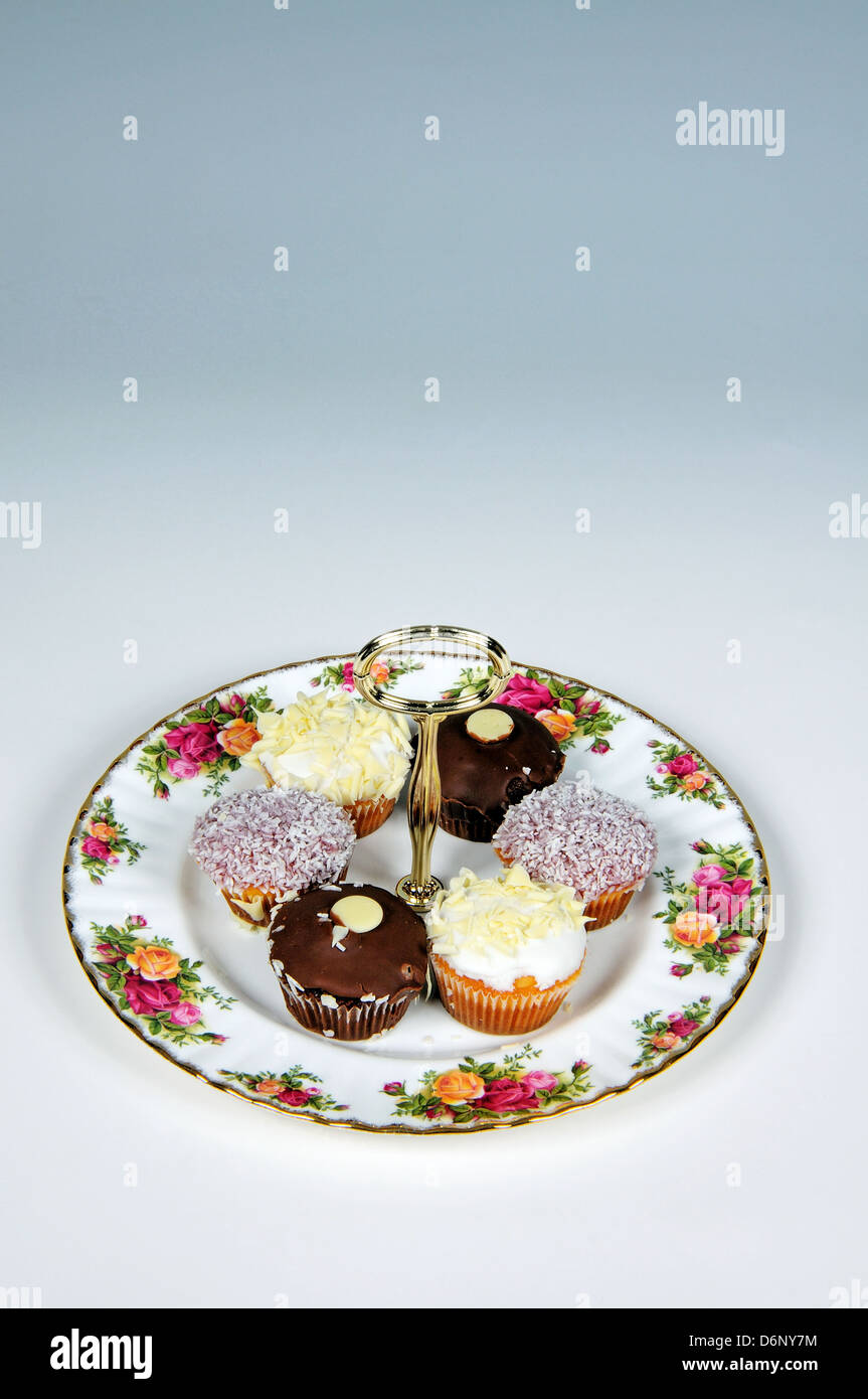 Cake plate with tea-time cake selection - Lemon drizzle cake, coconut madeleine and chocolate sponge. Stock Photo