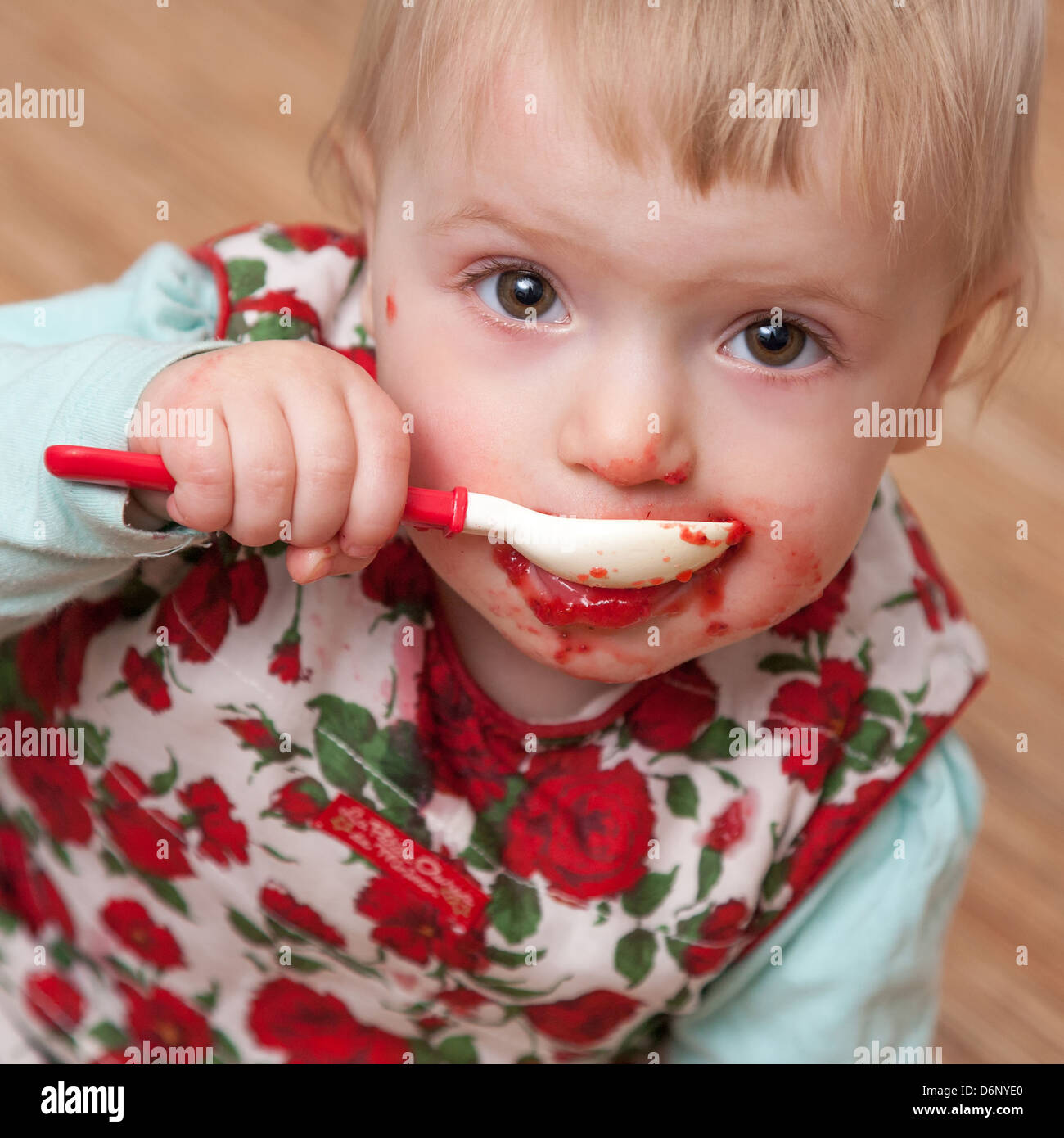 baby girl eating jam with a spoon, square crop Stock Photo Alamy